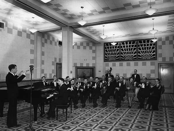 Isaac Mamott (left) conducts musicians in the newly-opened CKY radio studio, 1937