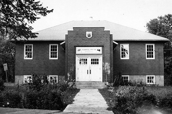The high school. With growing numbers of older students in the 1930s, more classrooms were needed so a high school was built on the grounds of the Consolidated School, just east of the earlier building. In the 1960s, as enrollment declined and a new central high school was built at nearby Sanford, the Starbuck High School was closed, used for a few years as a kindergarten and seniors centre, then demolished. The original school remains standing and is used by the community as a recreation and sports facility.