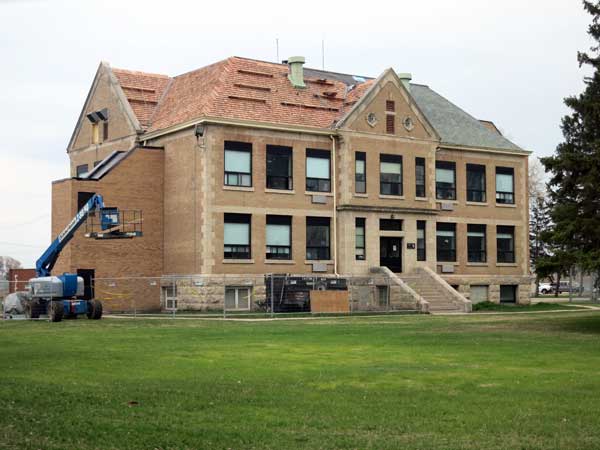 One of the remaining, older buildings at the Agassiz Youth Centre having new cedar roofing installed