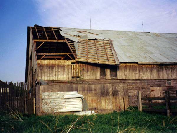 View of the damaged roof of the wooden barn building at the Armstrong Farm