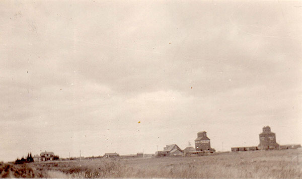 A view of Carnegie from the southwest showing section house, blacksmith’s house, blacksmith shop, Johnson (originally Watt’s) general store, Western Canada Four Mills grain elevator, and Ogilvie grain elevator