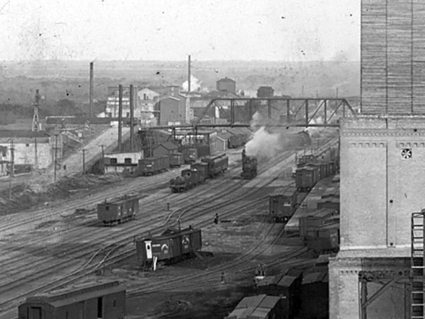 The steel trusses of the original Eighth Street Bridge are visible in the background of a photo of Brandon’s railway yard