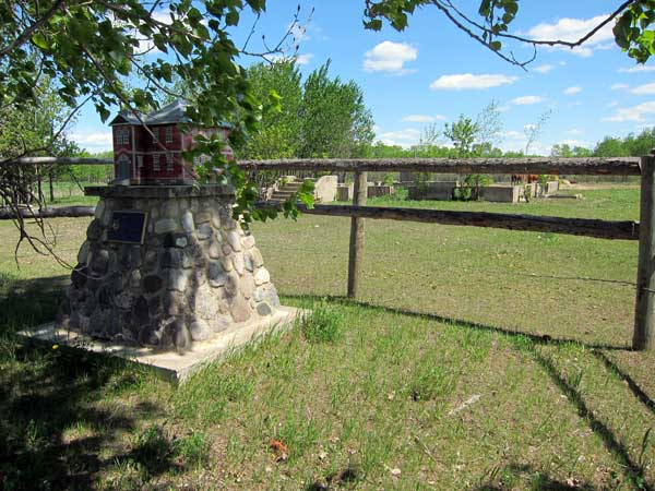 Makinak School commemorative monument with former school foundation in the background