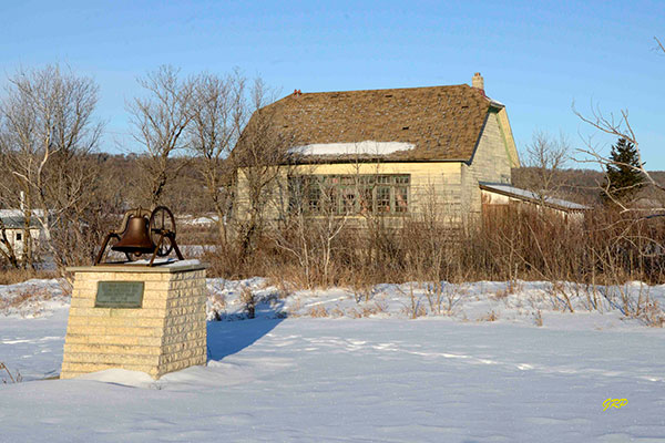 Millwood School commemorative monument with school building in background