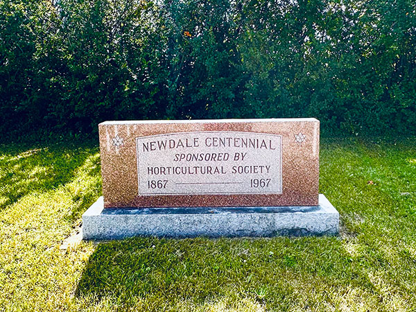 Newdale centennial monument behind the Newdale and District War Memorial