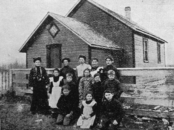 Students and teacher beside the old Ridgewood School