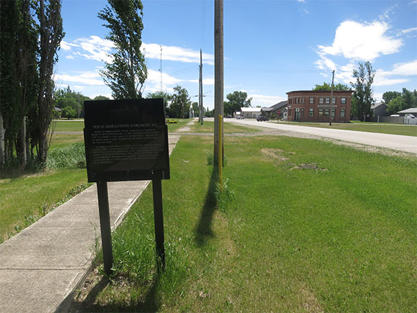 Commemorative sign for the United Grain Growers grain elevator at Roland, with the 4H Museum in the background
