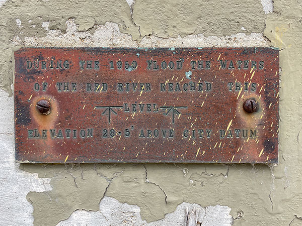 Plaque on inside of perimeter wall indicating height of 1950 floodwaters
