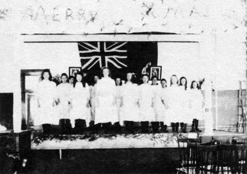 Interior of&nbsp;school classroom decorated for Christmas concert, circa 1915.