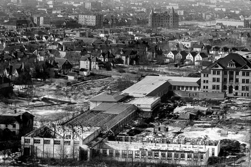 Building additions under construction with the original University building at right and Wesley College (now Wesley Hall, University of Winnipeg) in the background, just right of centre
