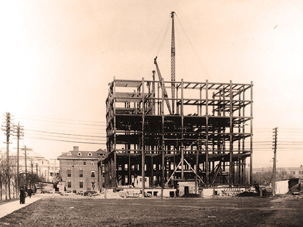 In this 1912 view of the steel skeleton for the Fort Garry Hotel taking shape, we see the Manitoba Club building immediately behind it and the Union Station, at the intersection of Broadway and Main Street, in the background