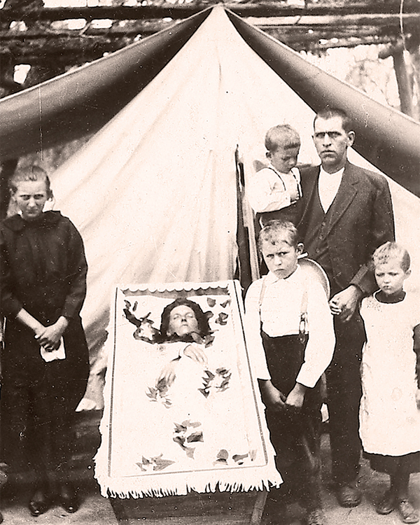 Katharina Braun (1890–1927) with her children and husband Jacob Braun (1887–1950) standing around the coffin, 24 March 1927. She died due to a strangulated bowel brought on by her pregnancy. This photo is an example of the difficult reality that pregnancy was not without risk and the death of a mother left a large gap in the family.