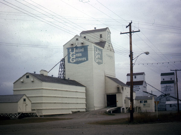 United Grain Growers grain elevator with the Manitoba Pool grain elevators in background, at Foxwarren
