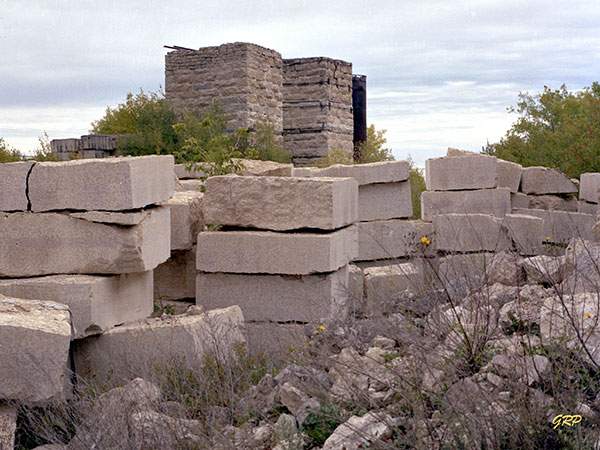 Cut blocks of Tyndall Stone at the Gillis Quarry, with lime kilns in the background