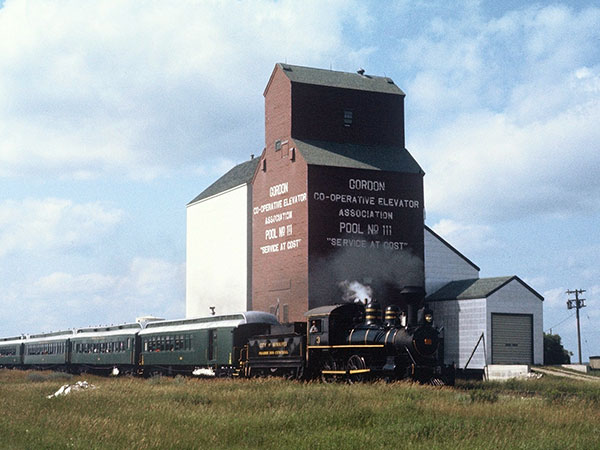 The former Manitoba Pool grain elevator at Gordon with the Prairie Dog Central train beside it