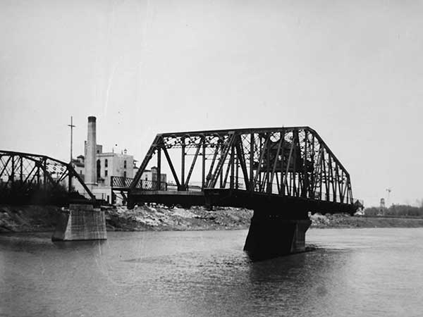 Redwood Bridge with visible overhead pilot cabin, swing span in operation, and Drewry Brewery in the background