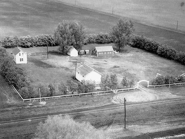 Aerial view of the Roseville School site showing the teacherage at left, barn at right, and a small white building that housed a woodworking shop for boys