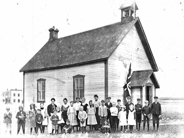 Shellmouth School building with teacher Belle McTavish and students