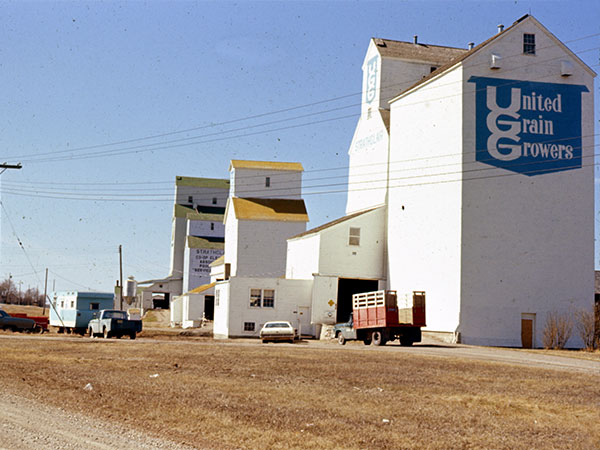 In the background of this photo of the United Grain Growers grain elevators at Strathclair is the original Manitoba Pool grain elevator being used as an annex for a newer elevator