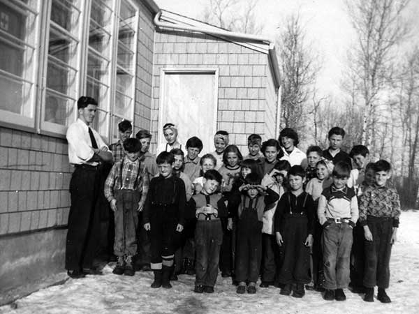Teacher Leonard Domaschuk with students outside the school building
